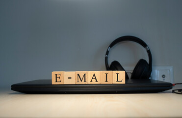 email word written on the background computer and headset concept. Closeup.