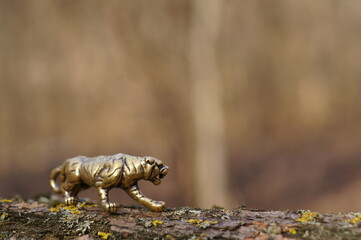 A metal tiger figurine on a dark background.
