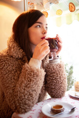 Young beautiful woman drinking mulled wine