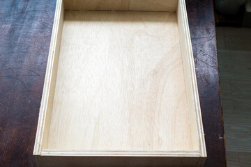 Naklejka na ściany i meble assembles wooden drawers of new furniture in the workshop.