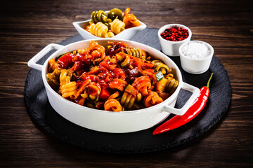 Pasta with tomato sauce, meat and parmesan on wooden table

