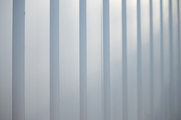 Shining reflective gray-blue metal panel striped wall receding into the distance