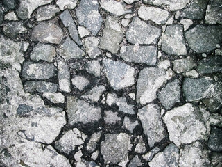 Old broken road in the city. Photo with cracks and destruction of the concrete surface.