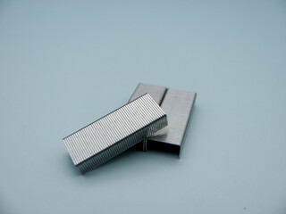 A set of stapler staples on a blue background close up.