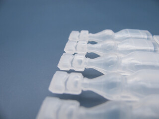 Set Lubricant eye drops in plastic pipettes blue background