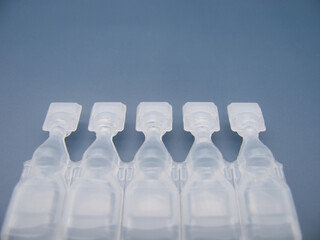 Set Lubricant eye drops in plastic pipettes blue background