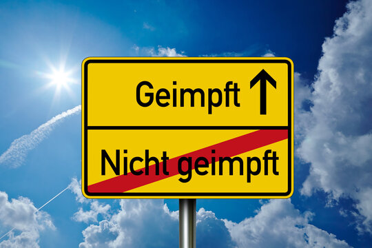 Road sign with the german words for covid-19 vaccination vaccinated and unvaccinated - geimpft und ungeimpft with blue sky background
