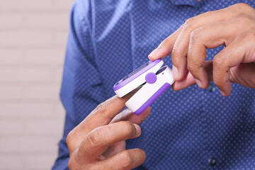 close up of man hand using pulse oximeter