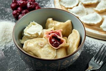 Ukrainian or Polish traditional dish - Pierogi or Varenyky (dumplings) stuffed with cherry and sour...