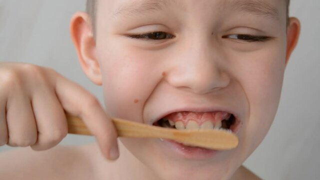 boy brushes his teeth with a wooden toothbrush. Super close-up. 