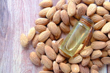 Almond oil in bottle on wooden background. top down