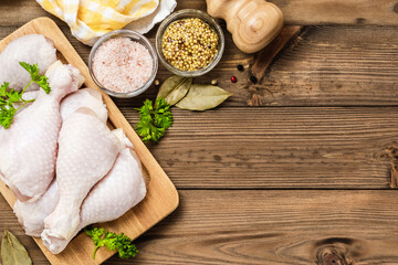 Poultry, raw chicken legs on wooden background. Top view, flat lay, space for text.