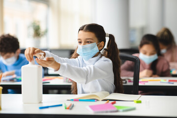 Small girl applying antibacterial sanitizer on hands