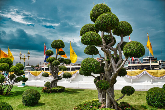 Beautiful, manicured park at the Temple of Dawn, Wat Arun buddhist temple, derives its name from the Hindu god Aruna often personified as the radiations of the rising sun
