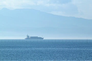 Quietly moving cargo ship and sea