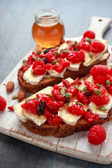Raspberry and brie sourdough bread toast with pumpkin seeds and drizzled with honey