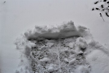 Pushed snow on a side walk during snow fall