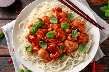 Sweet Chilli Chicken with noodles on wooden table. asian food