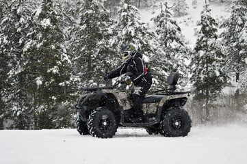 Fototapeta na wymiar a man drive an ATV in the snow 