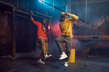 Obraz na płótnie Canvas Two stylish rappers, breakdancing in studio