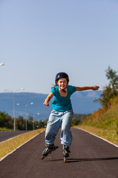 Teenage girl rollerblading against blue sky
