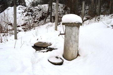 a fountain in the yard covered with snow