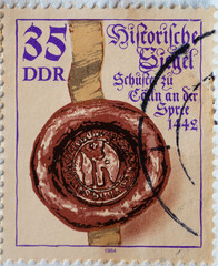 GERMANY, DDR - CIRCA 1984 : a postage stamp from Germany, GDR showing a historical seal with ribbon: Seal of the cobblers from Cölln an der Spree (1442)