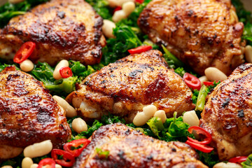 One-pot braised chicken thighs with kale and cannellini beans served with chili peppers