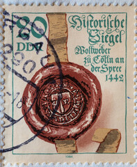 Fototapeta na wymiar GERMANY, DDR - CIRCA 1984 : a postage stamp from Germany, GDR showing a historical seal with ribbon: Seal of the wool weavers of Berlin (1442)