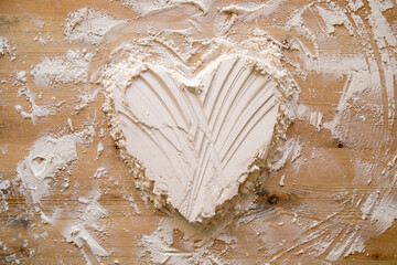 Valentine's Day. Heart symbol of love, made of flour on a wooden texture. Copy space. Conceptual.