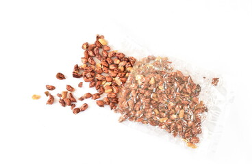 baked salty tiger stripe peel peanut pouring from clear plastic packaging on white background