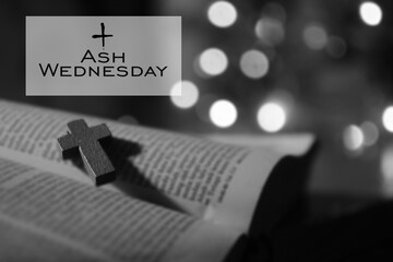 Ash Wednesday. Happy Ash Wednesday concept with wooden holy cross crucifix of Jesus Christ on open bible book page in black white background. First Day of Lent, beginning of the 40 day fasting.