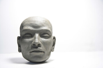 Fototapeta na wymiar Wet clay face, sculpture modeling on white background