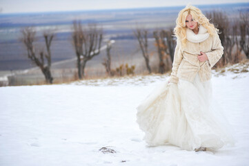 Beautiful bride near old castle on winter wedding day