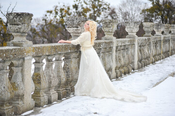 Beautiful bride near old castle on winter day wedding 