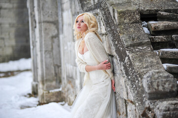 Beautiful bride near old castle on winter day wedding 