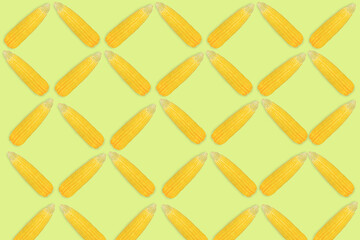 Top view or flat lay of fresh yellow Sweet corn isolated arranged in seamless pattern on light green background