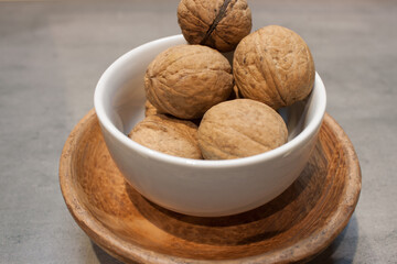 Walnuts kernels on dark desk with color background, Whole walnut in wood vintage bowl.