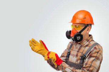 Construction worker putting on protective gloves over gray background. Personal safety equipment.