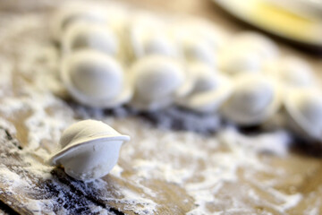 Traditional pelmeni or dumpling at cutting board. Homemade preparation food.