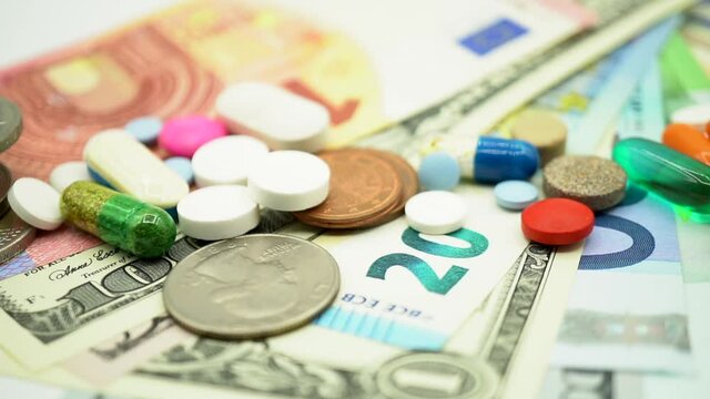 Treatment cost abstract concept with pills and RX medicine drugs on money or banknotes background
