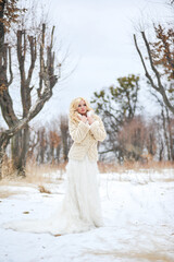 Portrait of a beautiful young woman, bride, in a winter forest