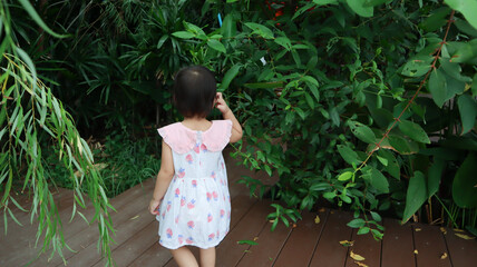 2 years old asian caucasian girl lost in the garden.