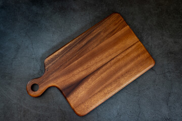 Wooden cutting board on a black marble table