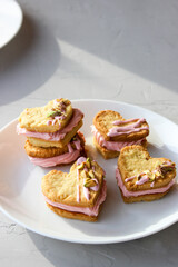 Holiday cookies in the shape of a heart, with cottage cheese cream and pistachios