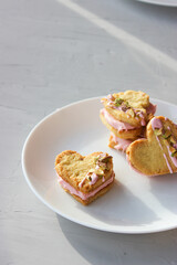 Holiday cookies in the shape of a heart, with cottage cheese cream and pistachios