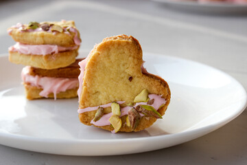 Holiday cookies in the shape of a heart, with cottage cheese cream and pistachios
