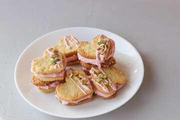Holiday cookies in the shape of a heart, with cottage cheese cream and pistachios