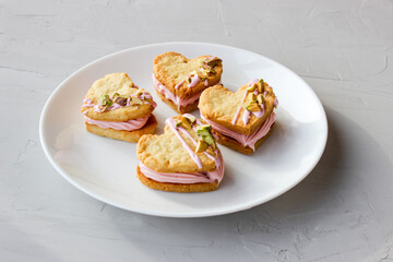 Holiday cookies in the shape of a heart, with cottage cheese cream and pistachios