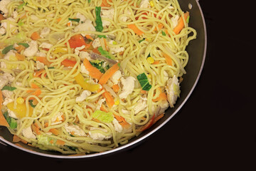 Egg Noodles With Chicken And Vegetables Cooking In A Wok Pan.